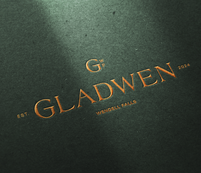 Gold metallic Gladwen logo on green paper